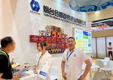 烟台合顺包装纸业有限公司制造和销售用于果蔬产品的礼盒包装。参展代表王先生（右一）。/ Yantai Heshun Packaging & Paper Industries Co., Ltd. manufactures and sells gift boxes for fruit and vegetable products. Representative Mr. Wang (first from the right) at the booth.