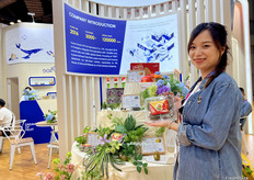 来自果寻梦的Manda Wu在展示公司特色产品红芯猕猴桃。除此之外，粑粑柑，蓝莓和黄心猕猴桃也是公司的主要销售产品。/ Manda Wu from Guoxunmeng showcases the company's specialty product, red kiwifruit. Other key products include tangerines, blueberries, and yellow kiwifruit.