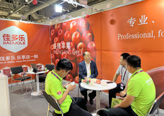 来自白水县润泉现代农业科技开发有限公司的董事长杨跃国先生（左二）正在与访客交谈。/ Mr. Yueguo Yang (second from left), Chairman of Baishui County Runquan Modern Agricultural Science and Technology Development Co., Ltd., is talking with visitors.