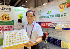 陕西新禧农业发展有限公司的总经理张全喜正在展示公司主打产品大荔冬枣。除冬枣外，公司还出口大荔水蜜桃，阳光玫瑰等产品。/ Quanxi Zhang, general manager of Shaanxi Xinxi Agricultural Development Co., Ltd., displays the company's flagship product, Dali winter dates. Besides winter dates, the company also exports Dali peaches and Shine Muscat Grapes.