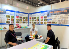 陕西广牧荣贸易有限公司的参展代表（左一，右一）在展位与访客交谈。/ Exhibition representatives from Shaanxi Guangmulong Trading Co., Ltd. (first from left, first from right) are talking with visitors at the booth.