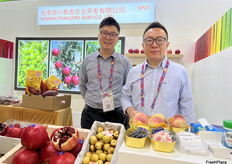 云南宾川泰吉农业开发有限公司的参展代表Ｋａｉ　Ｙｕａｎ　与Ｊａｃｋｙ　Ａｎ在展位前。/ Kai Yuan and Jacky An, exhibition representatives from Yunnan Thailucky Agricultural Development Co., Ltd., in front of the booth.