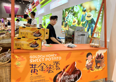 黄金蜜薯是广东省龙兴天露有限公司的主营产品之一，展位在现场进行烘烤，引来众多访客试吃。/ Golden Honey sweet potatoes are one of the main products of Guangdong Longxing Tianlu Co., Ltd. They were baked on site at the booth, attracting many visitors to try them.