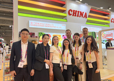 厦门冠威进出口有限公司的参展代表（左一，左二）与到访展位的海外客户合照。/ Representatives from Xiamen Guanwei Import & Export Co., Ltd. (first and second from left) are taking photos with overseas customers who are visiting the booth.