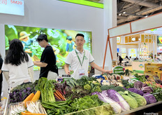 广东省龙兴天露农产品集团有限公司的参展代表在展台前。/ Representative from Guangdong Longxing Tianlu Agricultural Products Group Co., Ltd. in front of the booth.