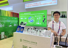 郑州鲜境电子有限公司的薛经理在展位前展示公司的多款温湿度记录仪产品。/ Manager Xue of Freshliance Electronics Corp., LTD is demonstrating the company's various temperature and humidity recorder products in front of the booth.