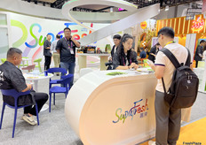 嘉果公司的参展代表正在与客户进行交谈。/ The exhibition representative from SupaFresh is talking with customers.