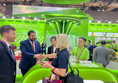 鲜丰水果的参展代表在展位与其客商见面。/ Xianfeng Fruit's representatives are meeting with their customers at the booth.