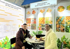 Sam Xing (1st from the left), sales manager at Zigui County Qugu Food Co., Ltd, is receiving a visitor at the booth. The company exports a variety of citrus products from China. / 秭归县屈姑食品有限公司销售经理Sam Xing（左一）正在展位接待访客。该公司从中国出口各种柑橘类产品。