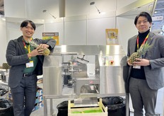 The sales manager Ryo Takeshita (1st from the left) from Astra and his colleague. The company brings its latest updated industrial pineapple corer-peeler to demonstrate at the exhibition. / Astra 的销售经理 Ryo Takeshita（左一）和他的同事。该公司携其最新升级的工业凤梨去芯去皮机参展。