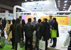 People have gathered at the stand of RKG Asia to enquire about and taste the Dori, and Italian kiwifruit variety currently being exported to China // 人们聚集在 爱奇果园亚洲有限公司展台前询问有关Dori的信息并进行品尝，Dori 是目前出口到中国的意大利猕猴桃。