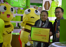 Helen Gong, President of the Shaanxi Betrue Organic Fruit Industry Group is receiving a brand award for the company's BE TRUE organic kiwifruit brand. To the right is Zender, organisator of Hi Fresh // 陕西本真有机果业集 团的总裁宫妤，为其本真品牌接收品牌奖，右边是亚洲果蔬博览会的 组织者朱勇立