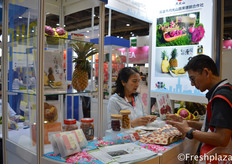 Gaoxiong Moonlight Mountain Vegetable and Fruit Marketing Cooperative busy talking with a customer. They export their Taiwanese produced pineapple and dragon fruit.高雄市月光山蔬果连锁合作社忙着和一位参观者交谈。他们出口台湾产的菠萝和火龙果。
