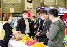 参展展商向观众介绍参展果品。